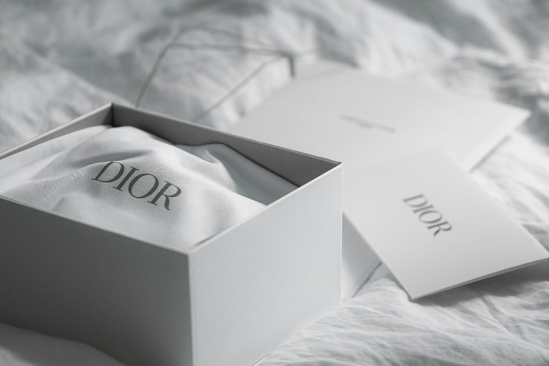 dior-box-with-cloth-and-card-on-white-fabric-dgldh2qfx4q